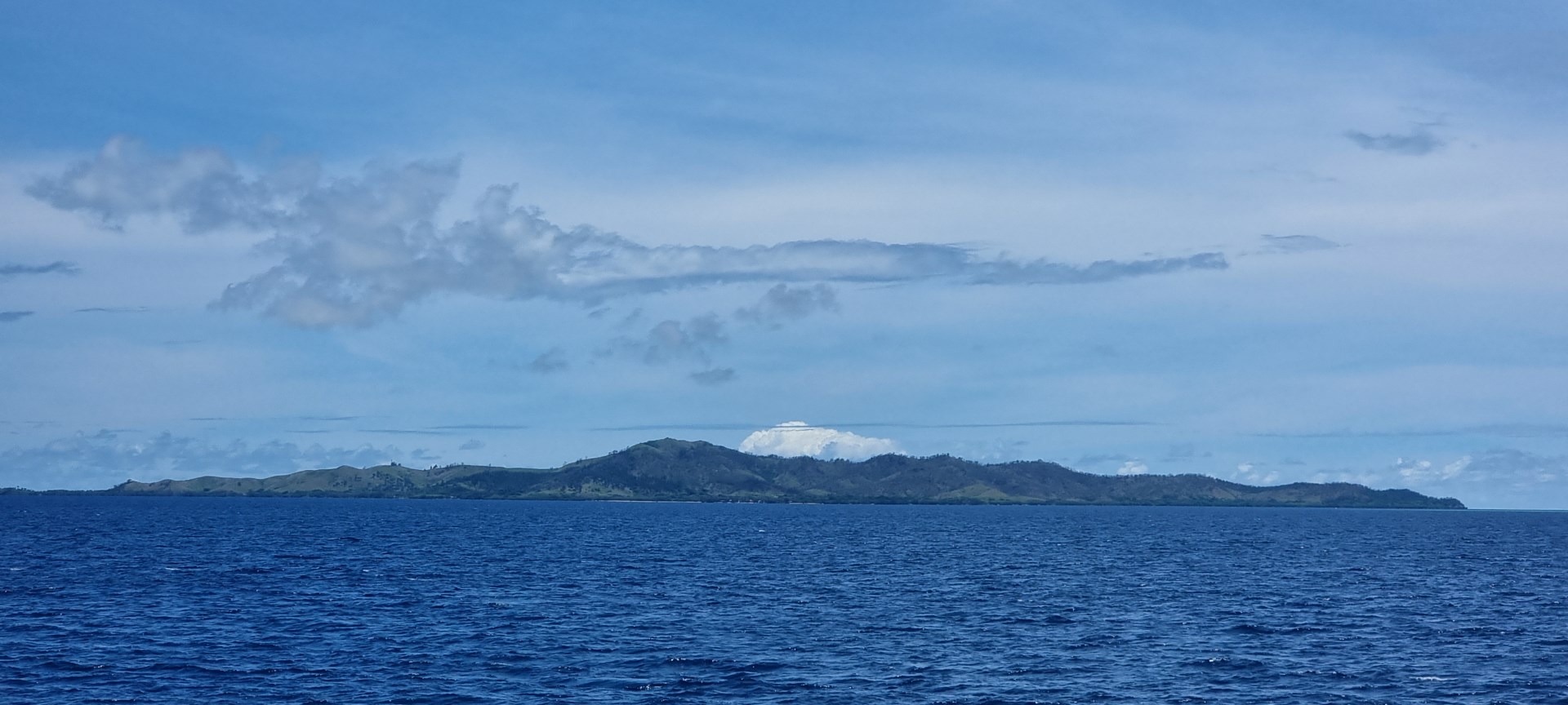 A panoramic view of Malolo Island’s green volcanic hills rising beyond the blue waters of Fiji’s Mamanuca Islands. - Photo Credit: JaumeBG