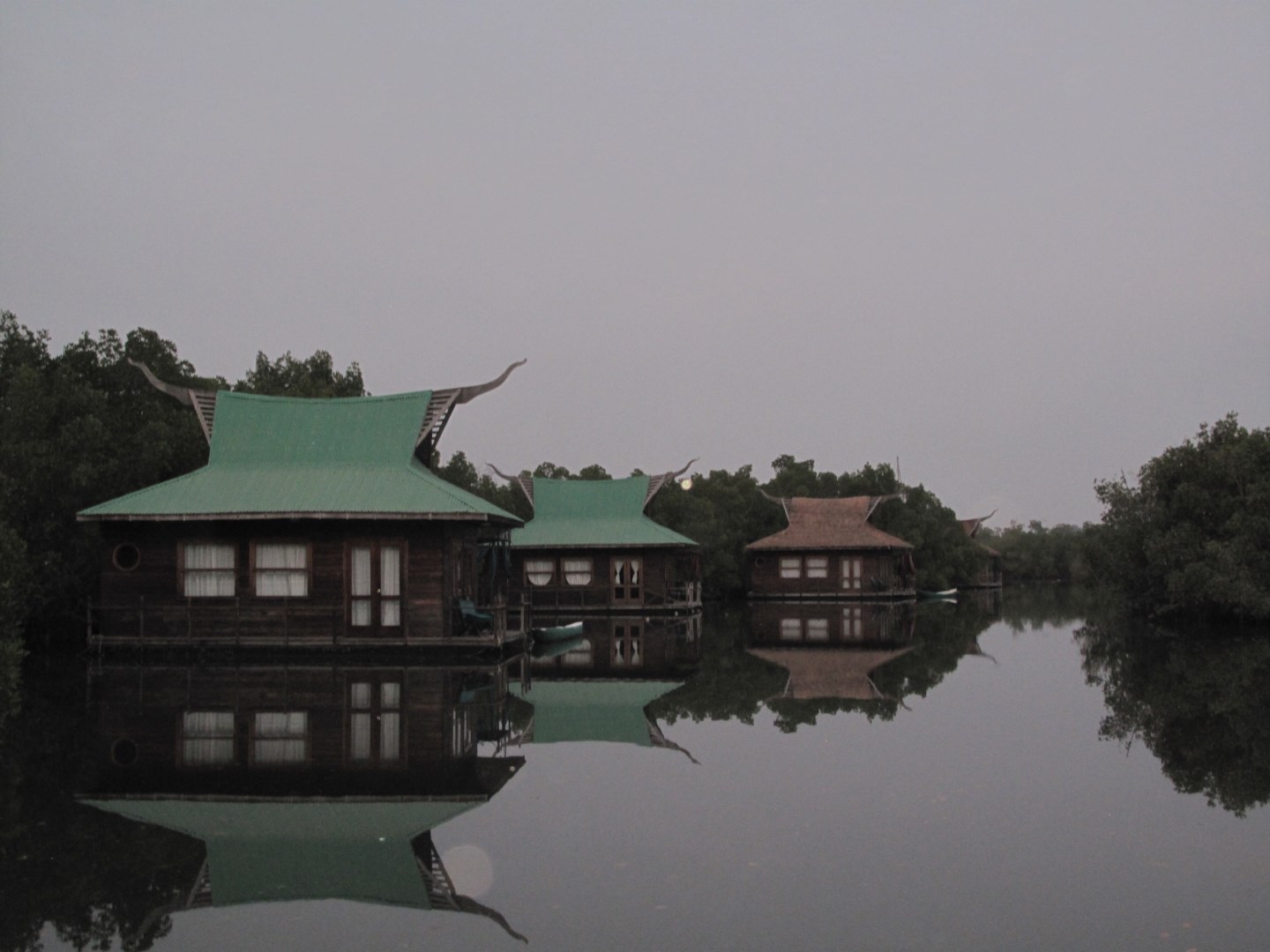 Floating lodges reflect in the still waters of Makasutu’s mangrove landscape at twilight. - Photo Credit: Forbes Johnston